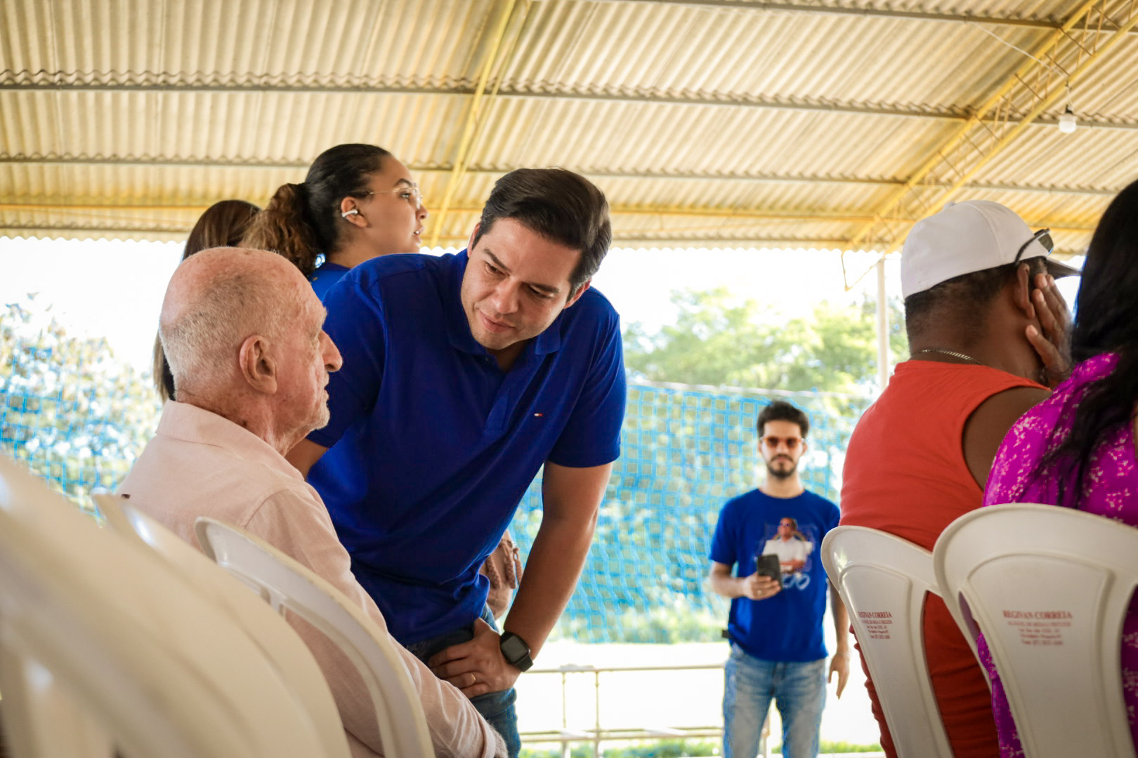 Túlio Arruda conversando com um morador idoso durante visita